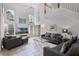 Bright living room featuring vaulted ceilings, large windows, tile flooring, and comfortable gray furniture at 909 Troon Cir, Davenport, FL 33897