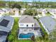 Aerial view of private screened pool with outdoor seating and lush landscaping around the pool area at 909 Troon Cir, Davenport, FL 33897