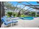 Inviting screened-in pool area with lounge chairs and lush landscaping for relaxing summer days at 909 Troon Cir, Davenport, FL 33897