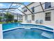 Stunning pool with attached spa and tile accents inside a screened-in lanai offers ultimate relaxation at 909 Troon Cir, Davenport, FL 33897