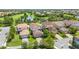 Aerial view of a community of homes with tile roofs surrounding a golf course and lake at 10067 Mere Pkwy, Orlando, FL 32832