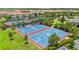 Aerial view of well-maintained basketball courts, surrounded by lush landscaping and neighborhood homes at 10067 Mere Pkwy, Orlando, FL 32832