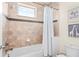 Bright bathroom features a tiled shower/tub combo with a window and tiled accent trim at 10067 Mere Pkwy, Orlando, FL 32832