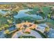 Aerial view of a lush golf course community with a central lake, the clubhouse, and surrounding homes at 10067 Mere Pkwy, Orlando, FL 32832