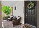 Covered front porch with comfortable seating and a welcoming wreath on the front door at 10067 Mere Pkwy, Orlando, FL 32832