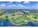 Aerial view of a lush golf course community with a central lake, the clubhouse, and surrounding homes at 10067 Mere Pkwy, Orlando, FL 32832