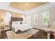 Elegant main bedroom with tray ceiling, dark hardwood floors and plush furnishings at 10067 Mere Pkwy, Orlando, FL 32832