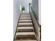 Staircase with dark wood steps, white risers, and a sleek metal railing leading to the upper level at 10067 Mere Pkwy, Orlando, FL 32832