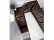 Aerial view of staircase with dark wood steps, white risers, and a sleek metal railing to upper level at 10067 Mere Pkwy, Orlando, FL 32832