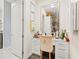 Elegant vanity area with a well-lit mirror, storage drawers, and a comfortable chair, leading to a walk-in closet at 10067 Mere Pkwy, Orlando, FL 32832