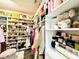 Well-organized walk-in closet with custom shelving and soft ottoman seating at 10067 Mere Pkwy, Orlando, FL 32832