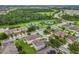 Aerial view of a residential neighborhood featuring townhomes, a park, tennis courts, and mature trees at 12606 Old Plantation Ln, Orlando, FL 32824