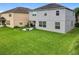 Exterior view of the back of home with a large backyard, green grass and patio at 12606 Old Plantation Ln, Orlando, FL 32824