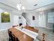 Bright dining area with a large table, modern light fixtures, and light gray walls at 12606 Old Plantation Ln, Orlando, FL 32824