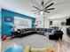 Open-concept living room with modern furniture, a blue accent wall and luxury vinyl flooring at 12606 Old Plantation Ln, Orlando, FL 32824