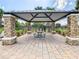 Community pavilion featuring stone columns, metal roof, brick pavers, and an outdoor picnic table at 12606 Old Plantation Ln, Orlando, FL 32824
