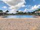 Community pool featuring brick pavers, lounge chairs, umbrellas, fountains and nearby cabanas at 12606 Old Plantation Ln, Orlando, FL 32824