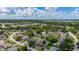 Scenic aerial view overlooking a residential area and lake featuring lush greenery and blue skies at 138 Hidden Pointe Ln, Groveland, FL 34736