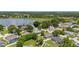 Aerial view of a serene community near a lake, surrounded by lush trees and residential homes at 138 Hidden Pointe Ln, Groveland, FL 34736