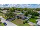 Aerial view of a home and neighborhood with green lawns, mature trees, and a white vinyl fence at 138 Hidden Pointe Ln, Groveland, FL 34736