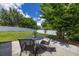 Outdoor patio space features a wrought iron table, chairs, and views of the landscaped backyard and white fence at 138 Hidden Pointe Ln, Groveland, FL 34736