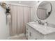 Bathroom featuring a marble vanity, decorative mirror, and stylish shower curtain at 138 Hidden Pointe Ln, Groveland, FL 34736