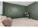 Bedroom showcasing green walls, updated baseboards, and a comfortable bed with pillows at 138 Hidden Pointe Ln, Groveland, FL 34736