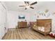 Bedroom with a ceiling fan, wood-look flooring, crib, dresser, and decorative wall art at 138 Hidden Pointe Ln, Groveland, FL 34736