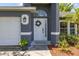 Close-up of a well-adorned front door with decorative wreath and accentuating potted plants at 138 Hidden Pointe Ln, Groveland, FL 34736