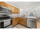 Well-lit kitchen with stainless steel appliances and light wood cabinets offers modern convenience at 138 Hidden Pointe Ln, Groveland, FL 34736