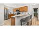 Well-lit kitchen featuring wood cabinets, modern appliances, and breakfast bar seating at 138 Hidden Pointe Ln, Groveland, FL 34736