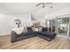 Bright living room features a ceiling fan, comfortable sectional sofa, and sliding glass doors to the backyard at 138 Hidden Pointe Ln, Groveland, FL 34736