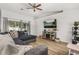 Bright living room features a ceiling fan, modern entertainment center, and sliding glass doors to the backyard at 138 Hidden Pointe Ln, Groveland, FL 34736