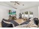 Bright living room features a ceiling fan, large windows, and a modern entertainment center at 138 Hidden Pointe Ln, Groveland, FL 34736
