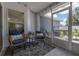 Enclosed patio with two chairs, side table and a black and white rug with leaf pattern at 138 Hidden Pointe Ln, Groveland, FL 34736