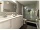 Modern bathroom featuring double vanity, marble-style glass shower, and gray wood-look tile flooring at 14205 Falls Church Dr # 2012, Orlando, FL 32837