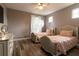 Bright bedroom featuring two twin beds, natural light, hardwood floors, and neutral paint at 14205 Falls Church Dr # 2012, Orlando, FL 32837