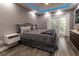 Modern bedroom featuring a gray upholstered bed, walk-out balcony, hardwood floors, and recessed lighting at 14205 Falls Church Dr # 2012, Orlando, FL 32837