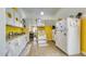 A quaint kitchen features white cabinets with sunflower accents and yellow walls, creating a bright and cheerful cooking space at 1431 Jack Calhoun Dr, Kissimmee, FL 34741