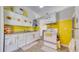 Bright kitchen featuring white cabinets with sunflower decor, yellow walls and ample lighting at 1431 Jack Calhoun Dr, Kissimmee, FL 34741