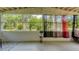 Enclosed patio featuring large windows and view of the lush outdoors with decorative curtains and tile flooring at 1431 Jack Calhoun Dr, Kissimmee, FL 34741