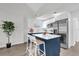 Well-lit kitchen featuring a large island, white cabinetry, stainless appliances, and breakfast bar at 1501 Missouri Ave, St Cloud, FL 34769