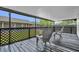 Covered patio featuring a black wood floor and two gray Adirondack chairs at 1501 Missouri Ave, St Cloud, FL 34769