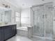 Bathroom featuring dual sinks, vanity, soaking tub, a large glass enclosed shower with custom tile, and natural light at 1513 Resolute St, Celebration, FL 34747