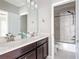 A modern bathroom features a double sink vanity, tile flooring, and a shower-tub combination at 1513 Resolute St, Celebration, FL 34747