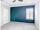 A cozy bedroom with a striking teal accent wall, plush carpet, and a window with shutters at 1513 Resolute St, Celebration, FL 34747