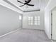 Spacious bedroom with neutral gray walls, plush carpeting, tray ceiling, fan, and bright natural light from shuttered windows at 1513 Resolute St, Celebration, FL 34747