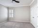 A well-lit bedroom includes a ceiling fan, plush carpet and a window with shutters at 1513 Resolute St, Celebration, FL 34747