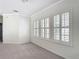 A bright bedroom showcases three windows with white shutters and plush gray carpeting at 1513 Resolute St, Celebration, FL 34747