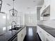 Modern kitchen with dark hardwood floors, white cabinets, granite countertops, and stainless steel appliances at 1513 Resolute St, Celebration, FL 34747